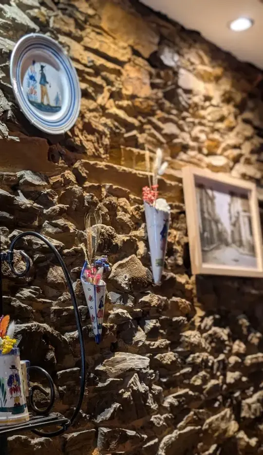 Mur de pierre et faïences anciennes dans la salle de Mamilig