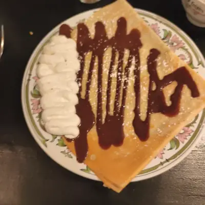 Crêpe de froment nappée de sauce chocolat, crème fouettée à côté