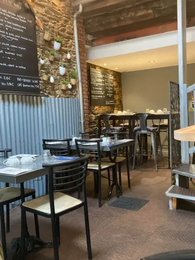 Salle de Mamilig, tables bistrot, mange-debout, mur de pierre et ardoise des suggestions